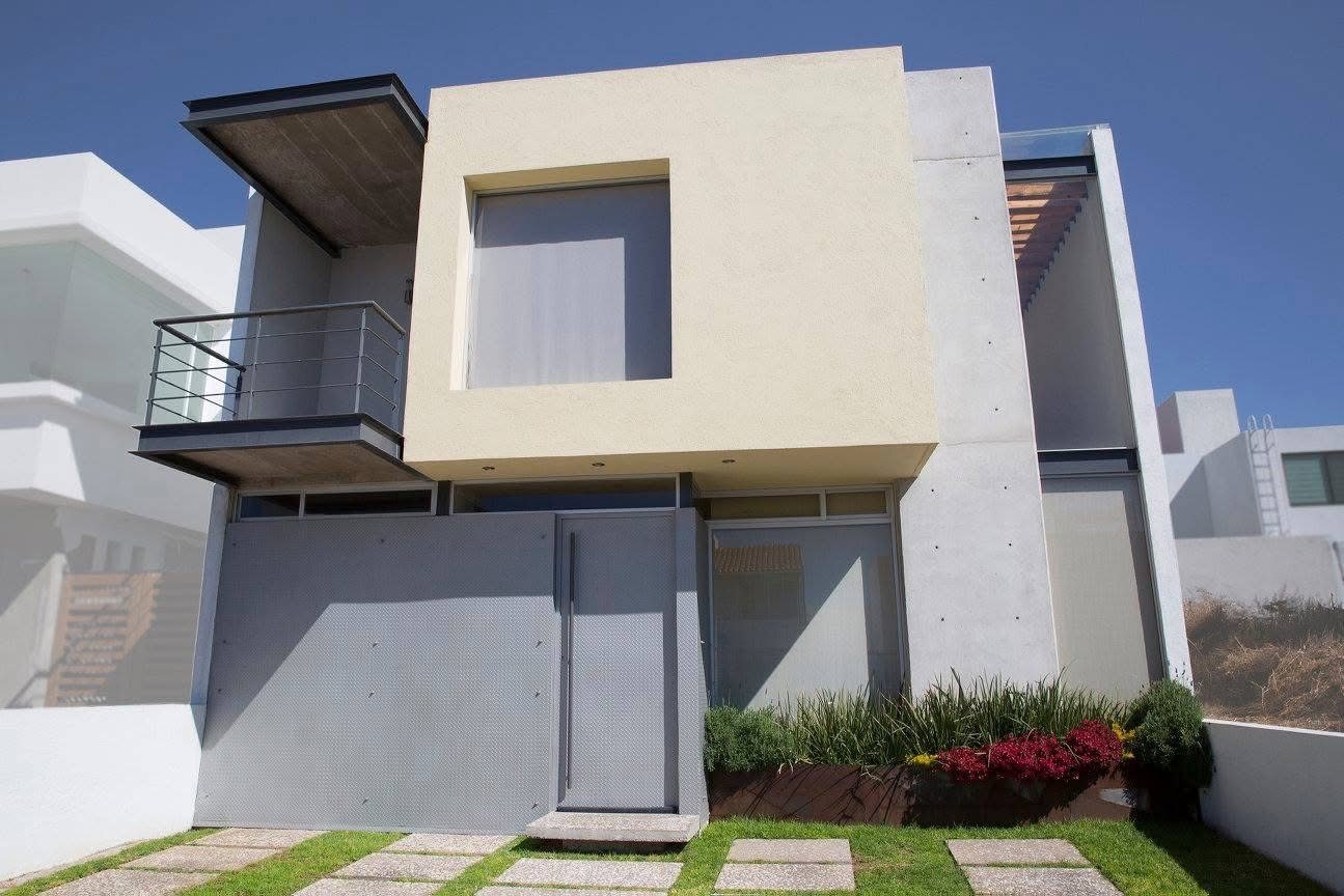 Fachada de dos niveles con volumen en cantiléver y concreto aparente
